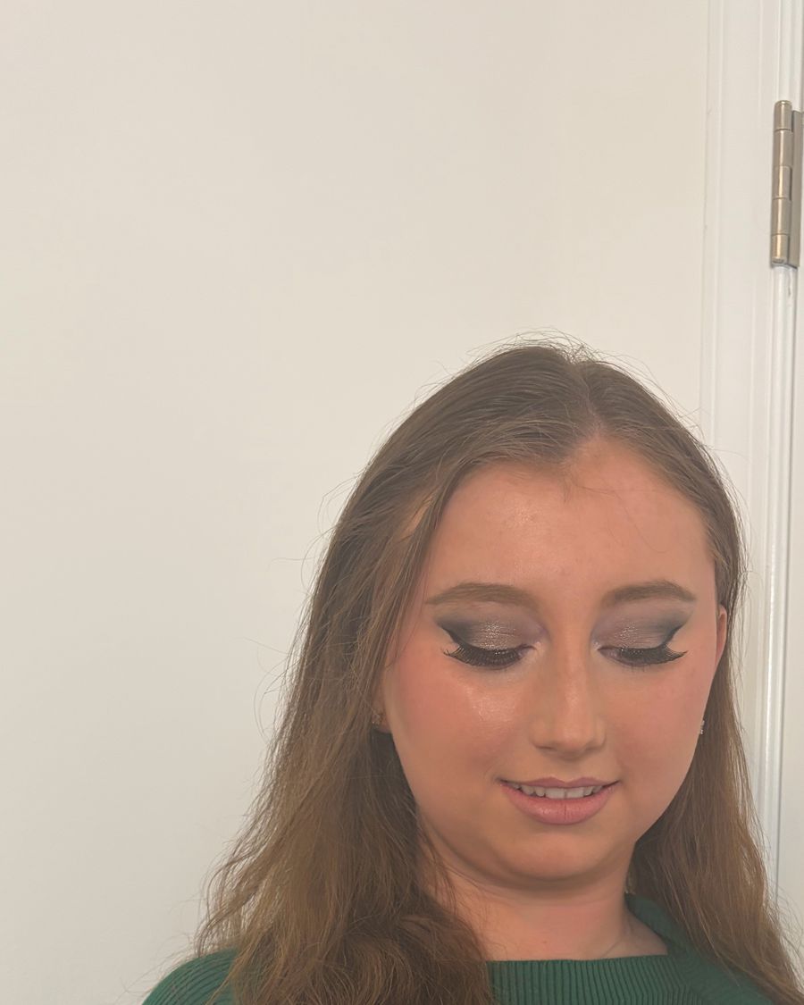 Defined eye makeup, hair worn long